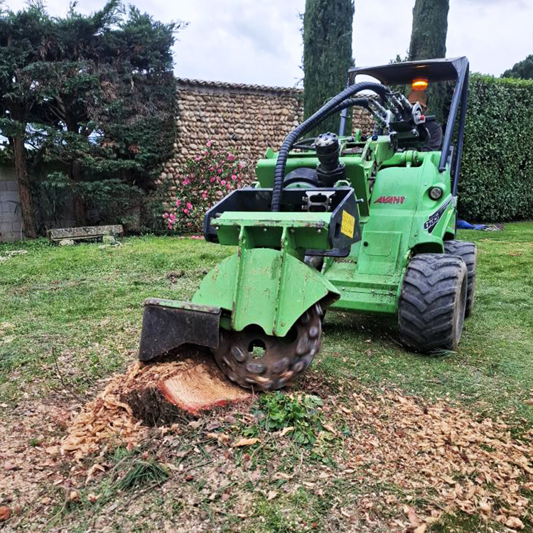 Machine de rognage de souche dans un jardin aménagé